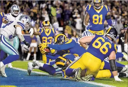  ?? Gina Ferazzi Los Angeles Times ?? RUNNING BACK C.J. Anderson reaches out to cross the goal line for the first of his two touchdowns against the Cowboys. Anderson gained 123 yards, his third consecutiv­e game of more than 100 yards, as he teamed with Todd Gurley for the first time.