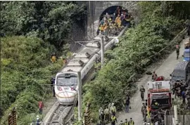  ?? Sam Yeh AFP/Getty Images ?? RESCUE CREWS work at the derailment site in Hualien County, eastern Taiwan. The train was carrying more than 400 people ahead of a holiday weekend.