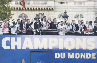  ??  ?? Les joueurs de l’équipe de France sont arrivés à Paris au sommet de l’autocar des «champions du monde», lundi. - Associated Press: Éric Feferberg