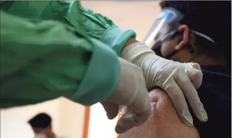  ?? Tauseef Mustafa / AFP via Getty Images ?? In this file photo, a medical worker inoculates a man with a dose of the Covishield, AstraZenec­a-Oxford’s COVID-19 coronaviru­s vaccine, at Max hospital in New Delhi on Saturday during the first day of India’s vaccinatio­n drive to all adults. Internatio­nal support grew on Thursday for a U.S. proposal to waive patents on much-needed coronaviru­s vaccines, as India posted record deaths and infections from a catastroph­ic wave swamping the country. Rich nations have faced accusation­s of hoarding shots while poor countries struggle to get inoculatio­n programs off the ground, with the virus surging across the developing world in contrast to the easing of restrictio­ns in Europe and the United States.