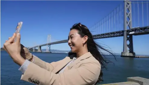  ?? ?? Content creator Cynthia Huang Wang works below the San Francisco-Oakland Bay Bridge in San Francisco, Monday, April 8, 2024.