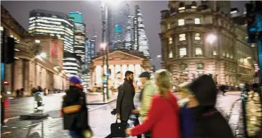  ?? — AFP ?? Higher risk: People making their way home through the drizzle in the City of London recently. A survey found the probabilit­y of two consecutiv­e quarters of negative growth has increased to 30% from last month.
