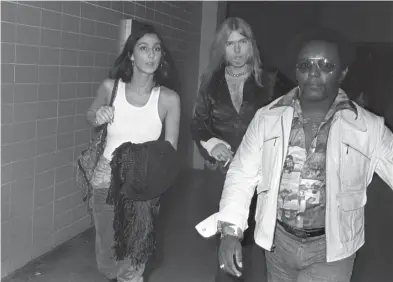  ?? THE COMMERCIAL APPEAL FILES ?? Dec. 14, 1975: With advance man Earl Simms leading the way, Cher arrives with Gregg Allman backstage at the Mid-south Coliseum prior to The Allman Brothers Band set before a reported 10,871 fans. Wet Willie was the opening act.