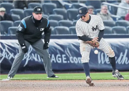  ?? JULIE JACOBSON/THE ASSOCIATED PRESS ?? Yankees third baseman Ronald Torreyes can't contain a bad hop on a ball hit by counterpar­t Yangervis Solarte of the Jays in the fourth inning Thursday.