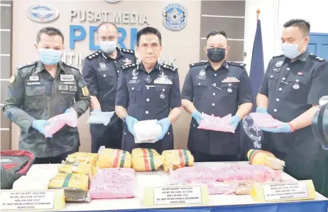  ?? Emmor — Photo by Roystein ?? Fisol (centre), GOF Sarawak commander SAC Mancha Ata (le ) and other senior officers show the drugs that were seized from the vehicle.