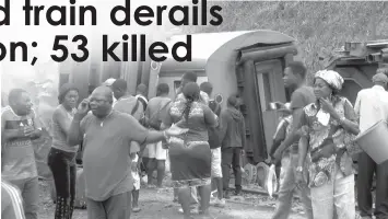  ?? ASSOCIATED PRESS ?? Passengers stand beside derailed train carriages after an accident in Eseka, Cameroon where at least 53 people died.