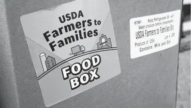  ?? CHARLIE NEIBERGALL/AP ?? Anti-hunger groups are pushing the Biden administra­tion to continue the USDA’s Farmers to Families Food Box program. Above, a food box is seen Feb. 18 at a Des Moines Area Religious Council mobile food pantry stop at the downtown bus station in Iowa.