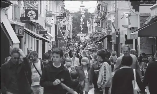  ?? Photo: AFP ?? Passers-by, with and without masks, walk in the main street of Le Touquet, western France on Saturday. France has 29,778 fatalities from 162,936 infected cases with COVID-19 as of Sunday.