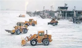  ?? [AP PHOTO] ?? Front-loaders clear snow from the area around Gates C and D outside Terminal B on Thursday at LaGuardia Airport in New York.