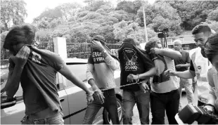  ??  ?? The nine men being led into the court room to be charged for rioting and causing injury. - Bernama photo