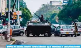  ??  ?? HARARE: An armored personnel carrier is stationed by an intersecti­on as Zimbabwean soldiers regulate traffic yesterday. — AFP