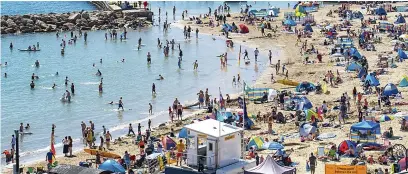  ??  ?? The mercury was already soaring as holidaymak­ers cooled off in the sea at Lyme Regis, Dorset, yesterday