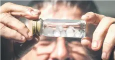  ?? ?? Seymour holding a vial containing Irukandji jellyfish in his work shed in the Queensland city of Cairns.