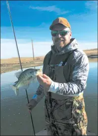  ?? Simonson Photo. ?? John Paczkowski of Bismarck, N.D. pauses with a nice white crappie caught on the fly rod during a break in the season’s gusty conditions.