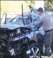  ?? Associated Press ?? SPEEDING
In this Feb. 23 file photo, a law enforcemen­t officer looks over a damaged vehicle following a rollover accident involving golfer Tiger Woods in the Rancho Palos Verdes suburb of Los Angeles.