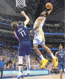  ?? TONY GUTIERREZ AP ?? Warriors’ Andrew Wiggins goes up for a dunk over Mavericks’ Luka Doncic.