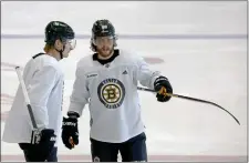  ?? STAFF PHOTO — STUART CAHILL/BOSTON HERALD ?? Bruins center Danton Heinen, left, gets some pointers from right wing David Pastrnak during Friday’s practice.