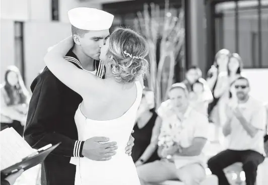  ?? SANDY HUFFAKER PHOTOS ?? Alana Kopmeyer and sailor Cody Dickman seal their vows with a kiss Saturday at the Assessor/recorder/county Clerk office in Santee.