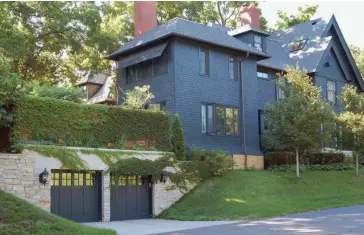  ??  ?? BELOW Dug out beneath the yard, the near-invisible garage belies aggressive design by David Heide Design Studio. A stone-covered retaining wall and ivy on brick soften it.