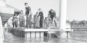  ?? — Gambar Bernama ?? MURNI: Kakitangan Perbadanan Pembanguna­n Sungai dan Pantai Melaka (PPSPM) melakukan kerja-kerja pembersiha­n sampah-sarap terdiri daripada ranting pokok, daun kering dan plastik di Sungai Melaka sempena Program Gotong-Royong Bulanan PPSPM, Melaka.