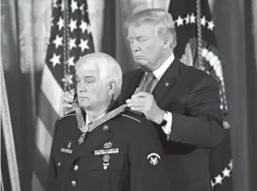  ?? Associated Press ?? n President Donald Trump bestows the nation’s highest military honor, the Medal of Honor, on retired Army medic James McCloughan during a ceremony Monday in the East Room of the White House in Washington. McCloughan is credited with saving the lives of...