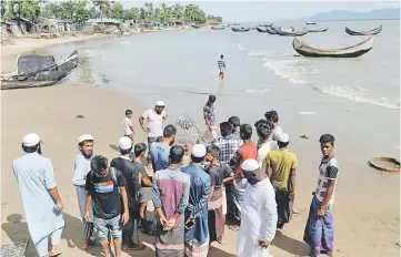  ??  ?? Local residents gather around bodies of Rohingya refugee children from Myanmar who were killed when their boat capsized on the way to Bangladesh, in Shah Porir Dwip, Teknaf, near Cox’s Bazar in Bangladesh. — Reuters photo