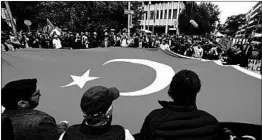  ?? ANDREAS GEBERT/GETTY ?? Members of the Turkish community hold a flag in a show of unity outside a Munich court.