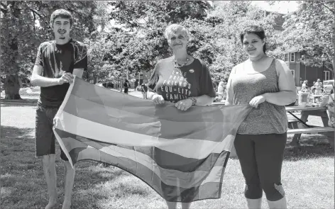  ?? KATHERINE HUNT/THE GUARDIAN ?? Brandon MacLeod, from left, Michelle Campbell, and Cassidy Lewis proudly hold the Pride flag up at the 2018 P.E.I Pride Week kickoff barbeque held in Rochford Square in Charlottet­own on Sunday.