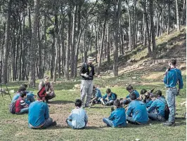  ??  ?? Louis Junior Saad, centre, and Martin Kaech, crouched at left, teach boy scouts about bird migration and illegal hunting, in Hammana, Lebanon.
