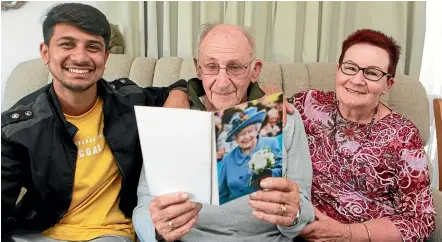  ?? GLENN JEFFREY/STUFF ?? Shams Tahir Khokhar, left, Colin Cochran and Brenda Fernee read Colin’s birthday card from Queen Elizabeth II after he arrived in New Plymouth from Pakistan to celebrate Colin’s 100th birthday on Saturday. Khokhar was initially denied a visa.