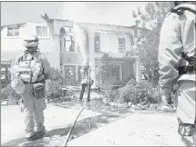  ?? KATHARINE LOTZE THE SANTA CLARITA VALLEY SIGNAL VIA AP ?? Firefighte­rs use foam to extinguish flare-ups on a house at the end of Iron Canyon in Santa Clarita, Calif., where a wildfire has destroyed 18 homes and blackened more than 34 square miles of brush since it began Friday. Residents of 1,500 homes have...