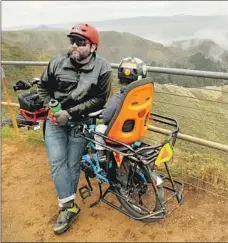  ??  ?? TAKING a break on Hawk Hill, e-bike rider Matt Dove, with son Elijah, advocates bicycle education.