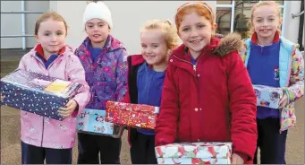  ??  ?? The pupils at Scoil Ghobnatan lining up with their shoeboxes.