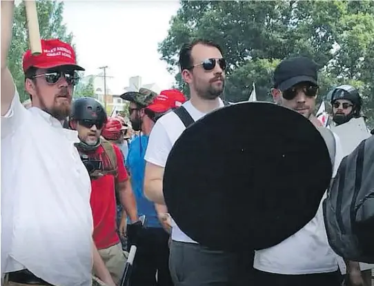  ??  ?? Zeiger, centre, at the Unite the Right rally in Charlottes­ville, Va., in August 2017: he used his infamy as a recruiting tool, sharing hyperlinks to his Daily Stormer articles and podcast appearance­s.