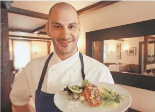  ??  ?? FRESH FARE: Winsor House Inn chef Franco Carubia shows off a wild salmon dish that uses herbs and vegetables from the inn’s garden.