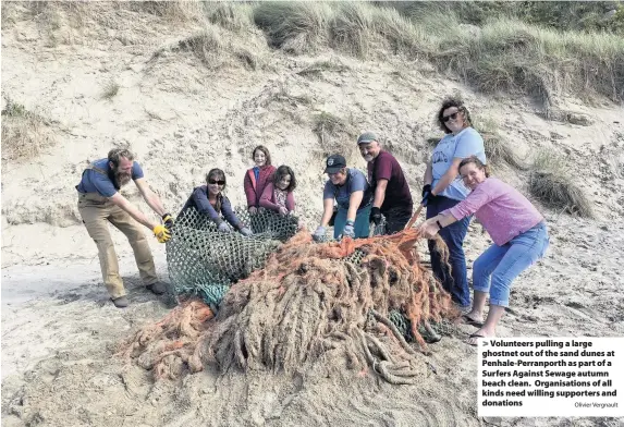  ?? Olivier Vergnault ?? Volunteers pulling a large ghostnet out of the sand dunes at Penhale-Perranport­h as part of a Surfers Against Sewage autumn beach clean. Organisati­ons of all kinds need willing supporters and donations