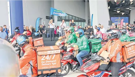  ?? — Bernama photo ?? Fahmi flags off the convoy of riders to mark the launch of the ‘Rahmah P-hailing Package’.