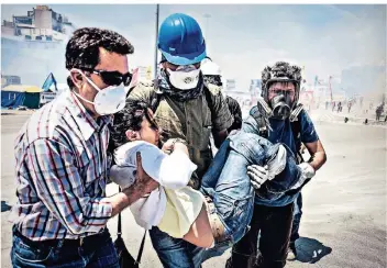  ?? FOTO: DPA ?? Eine verletzte Frau wird im Juni 2013 von Helfen aus dem Zentrum der Demonstrat­ionen in Istanbul getragen.