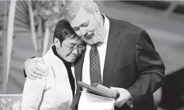  ?? ALEXANDER ZEMLIANICH­ENKO/AP ?? Fighting for freedom: Nobel Peace Prize winners Dmitry Muratov from Russia, right, and Maria Ressa of the Philippine­s, embrace Friday during the Nobel Peace Prize ceremony at Oslo City Hall, Norway. The Norwegian Nobel Committee cited Ressa and Muratov’s fight for freedom of expression, stressing that it is vital in promoting peace.