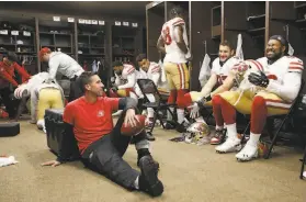  ?? Michael Zagaris / Getty Images ?? 49ers coach Kyle Shanahan talks with defensive linemen Nick Bosa and Sheldon Day (right) in the locker room before a game at Washington on Oct. 20.