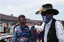  ?? Chris Graythen, Getty Images ?? NASCAR legend and team owner Richard Petty stands with driver Bubba Wallace for the national anthem on Monday.