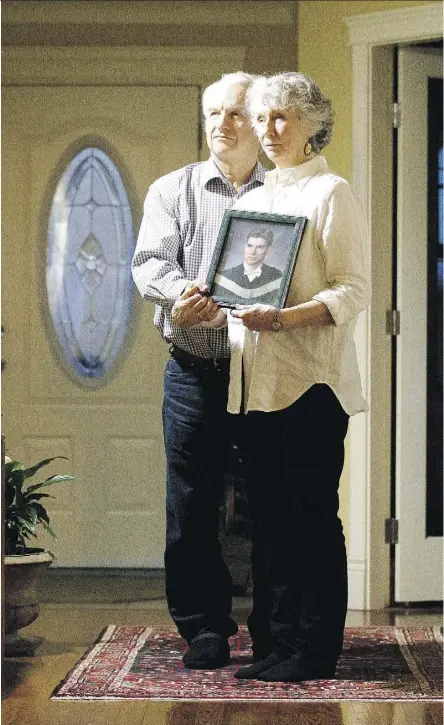  ?? DAVID BLOOM ?? Joshua Stebbins’ mother Kathryn Fearnley and his stepfather Ken Fearnley hold a portrait of Joshua in their Edmonton home. Joshua was killed in Asheville, N.C. last year.