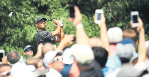  ?? GREGORY SHAMUS GETTY IMAGES ?? Tiger Woods hit the ball beautifull­y Friday, but couldn’t sink a putt in his second straight even-par round: “The name of the game is you’ve got to make putts.”