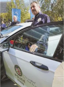  ?? AP PHOTOS ?? CHARGING FORWARD: Los Angeles police Chief Charlie Beck, above, gets into a prototype of the Ford Fusion police hybrid car. Ford says the vehicle will get 38 mpg, more than double that of its Ford Taurus Police Intercepto­r.