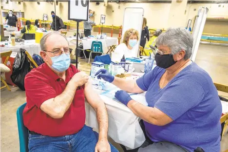  ?? APRIL GAMIZ/THE MORNING CALL ?? Richard McGarrigle, of Doylestown, receives his second vaccine from paramedic Krista Benner on March 3 at the Agri-Plex the Allentown Fairground­s.