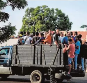  ?? AFP ?? La caja de un camión tomada al asalto por decenas de personas en Maracaibo