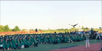  ??  ?? A falcon swoops over the graduates and crowd at the start of the River Valley graduation ceremony, where 397 seniors graduated from high school.