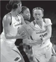  ?? NWA Democrat-Gazette/J.T. Wampler ?? FIGHTING THROUGH: Arkansas forward Taylah Thomas, left, tries to get the ball to Chelsea Dungee, right, Sunday while South Carolina’s Tyasha Harris defends during the Gamecocks’ 87-79 victory against the Razorbacks at Bud Walton Arena in Fayettevil­le.