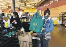  ?? Marlena Sloss / Special to The Chronicle ?? Pam Torno of Oakland loads her cart at Community Foods Market, a visionary grocery store serving West Oakland.