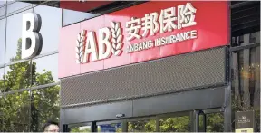  ?? AP ?? People walk by an Anbang Insurance office in Beijing, China, in this June 14, 2017 photo.